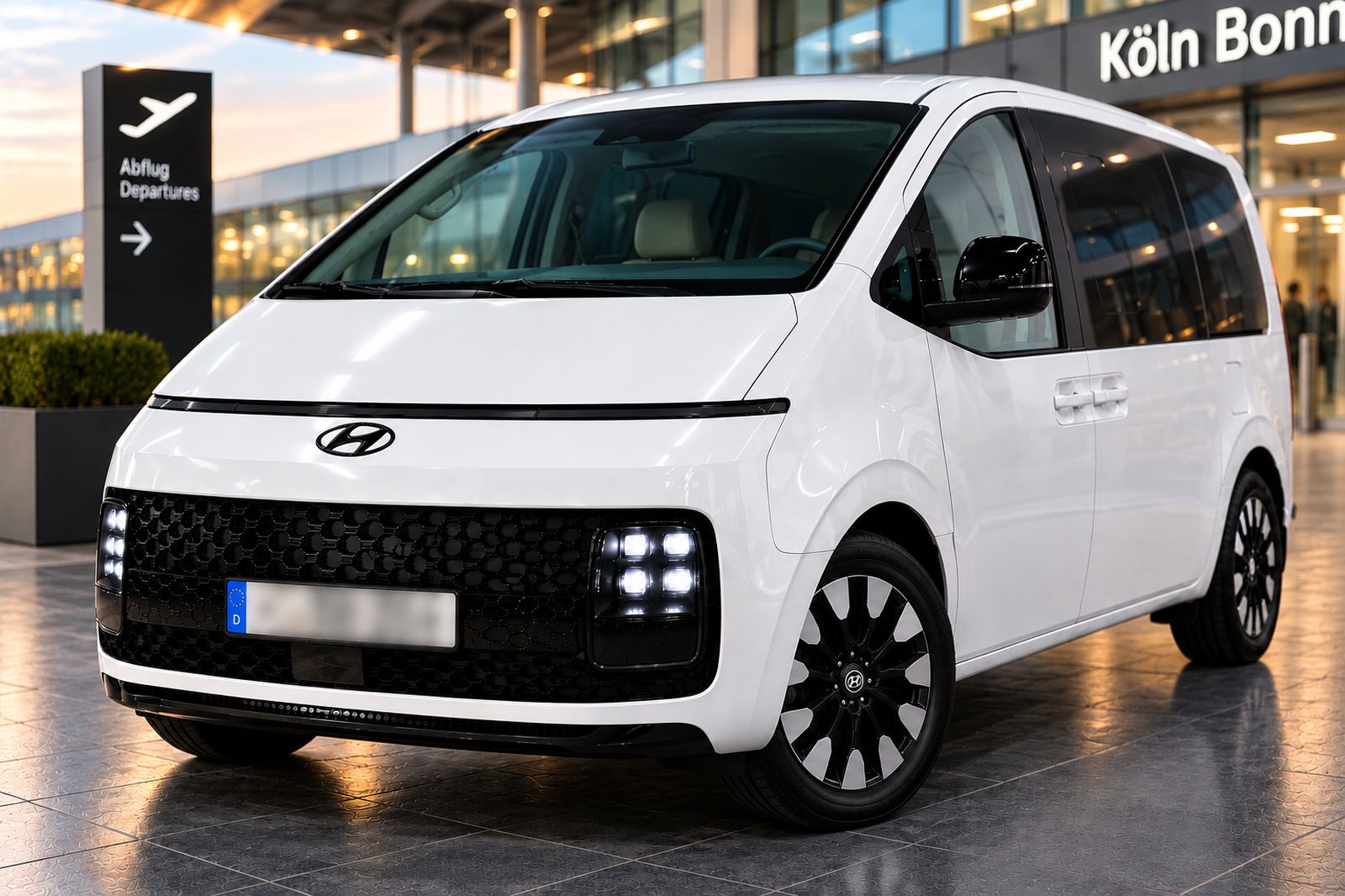 سيارة Hyundai Staria بيضاء تابعة لـ TaxiRond أمام صالة مطار كولونيا/بون